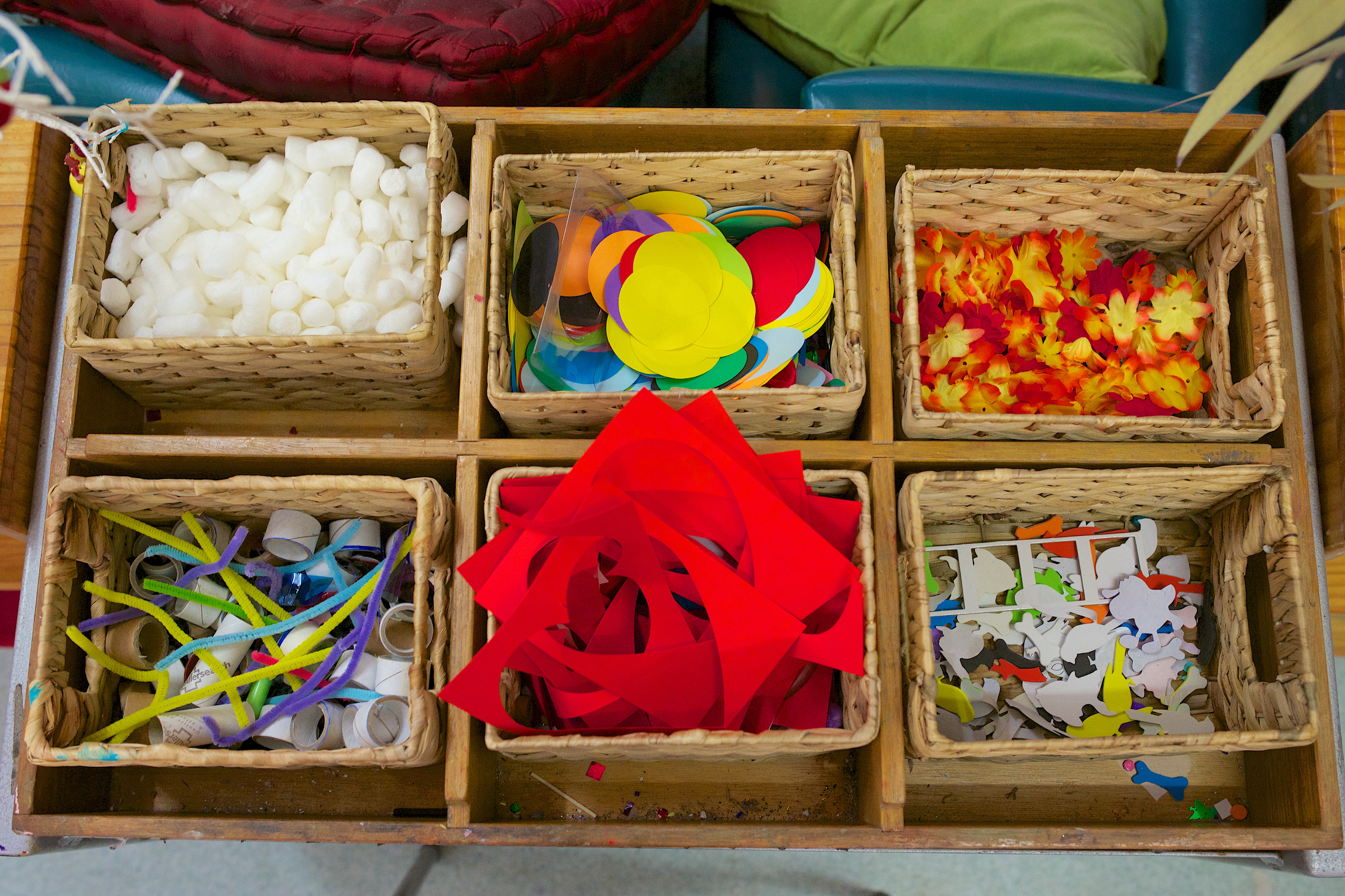 Looking down on six small baskets full of art supplies